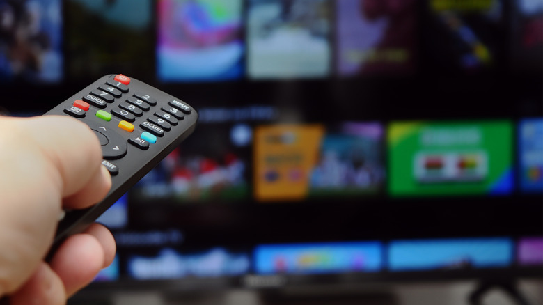 A person pointing a remote at a smart tv