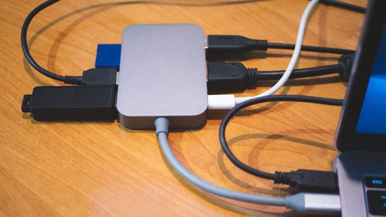 A USB-C hub with various cables connected. It's also connected to a laptop.
