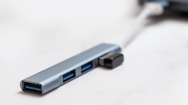 A USB-C hub with various cables connected. It's also connected to a laptop.