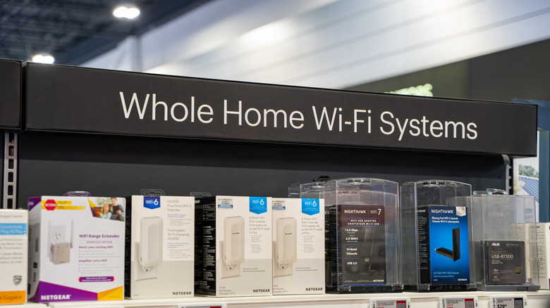 A retail store shelf lined with several types of routers.
