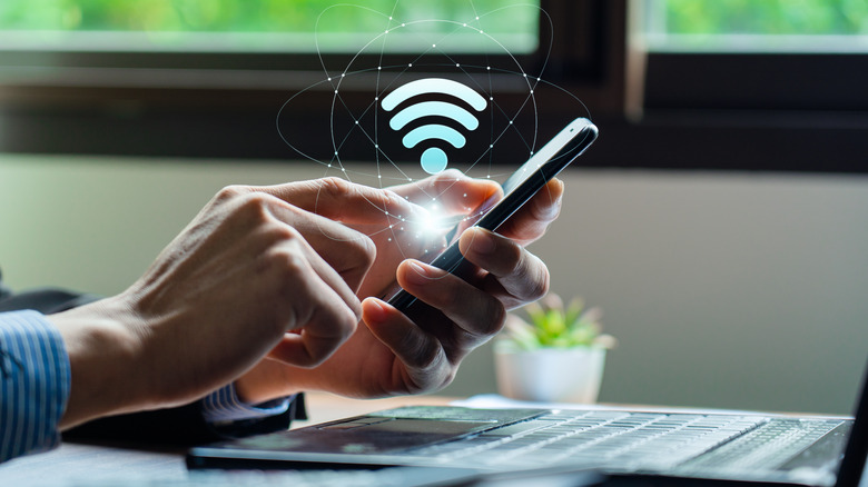 A person using a phone with a Wi-Fi symbol on top