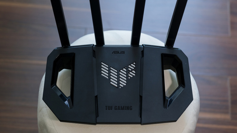 asus tuf gaming router with four antennal placed on a white cushion