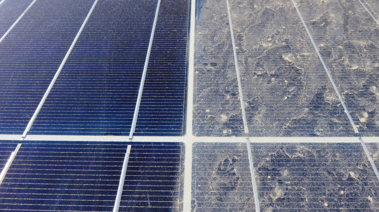 Solar panels, with half covered in dirt