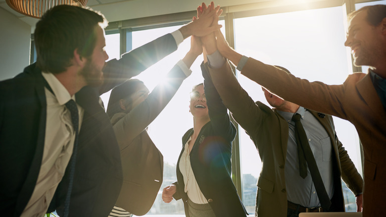 happy workers giving each other a high five at their jobs
