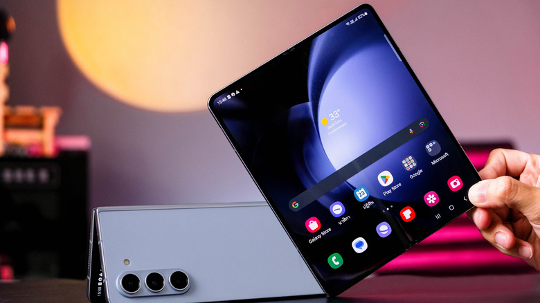 Two Galaxy Samsung Galaxy Z Fold 5s, one folded in tent mode and one open in a user's hands