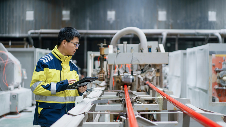 Concept, factory worker looking over an assembly line