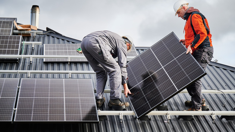 Technicians installing solar panels on a rooftop