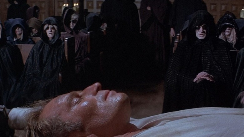 Robert Neville (Charlton Heston) laid out in front of The Family who are watching him in The Omega Man