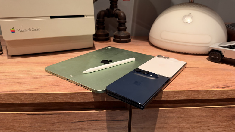 iPad Air with Apple Pencil on top next to two iPhone Duos