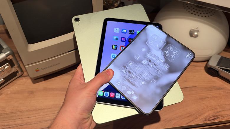iPad Air, iPad mini, and iPhone Duo all being held in one hand