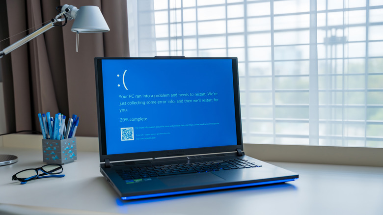 A laptop displaying a Windows error message is pictured.