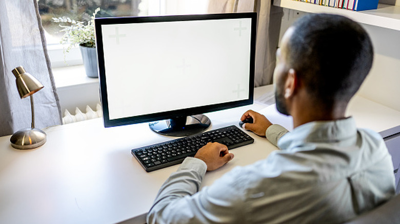 Man working at desk with computer monitor