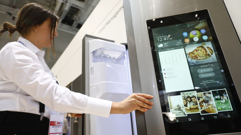 woman opening samsung smart fridge on show floor
