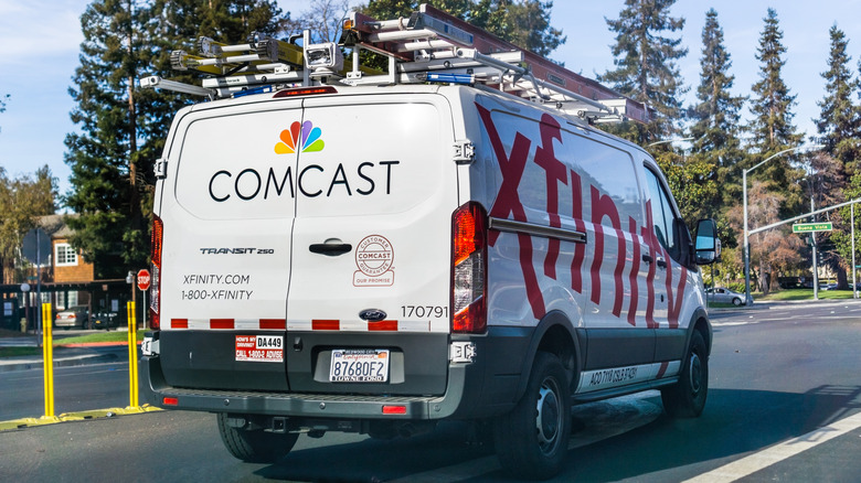 a service truck of Comcast on the road with the Xfinity logo on its side