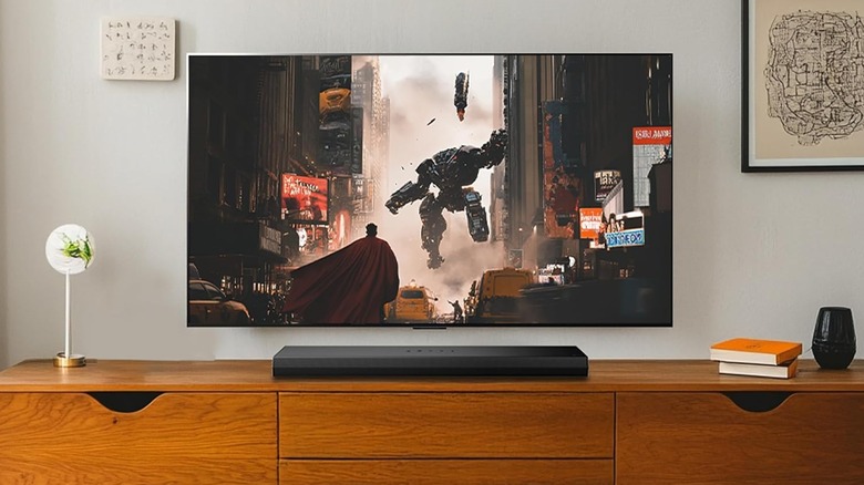 The LG S20A placed on a TV stand below a wall-mounted TV.