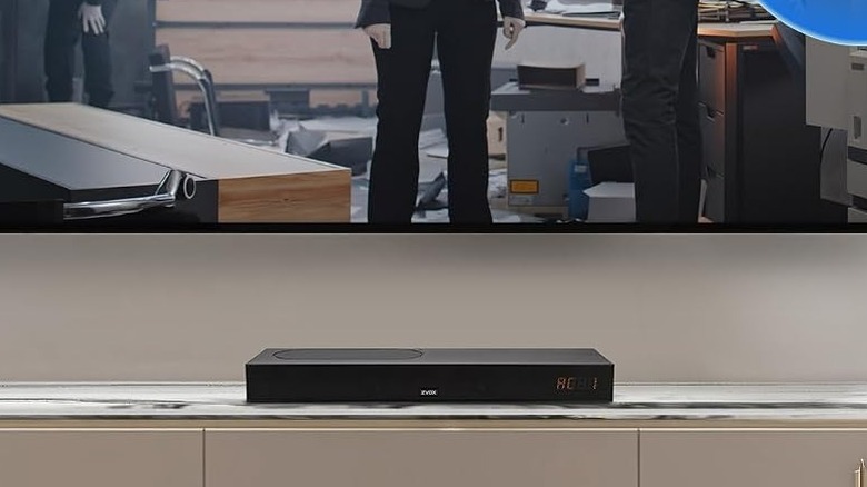 The ZVOX AccuVoice AV835 placed on a TV stand below a wall-mounted TV.