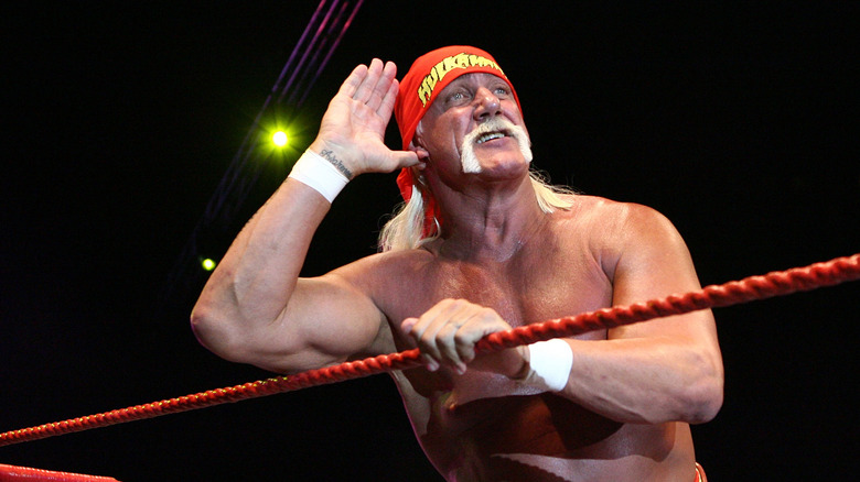 Hulk Hogan listening to the fans with hand to ear