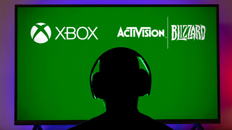 person sitting in front of a tv with Xbox, Activistion Blizzard logo on green background