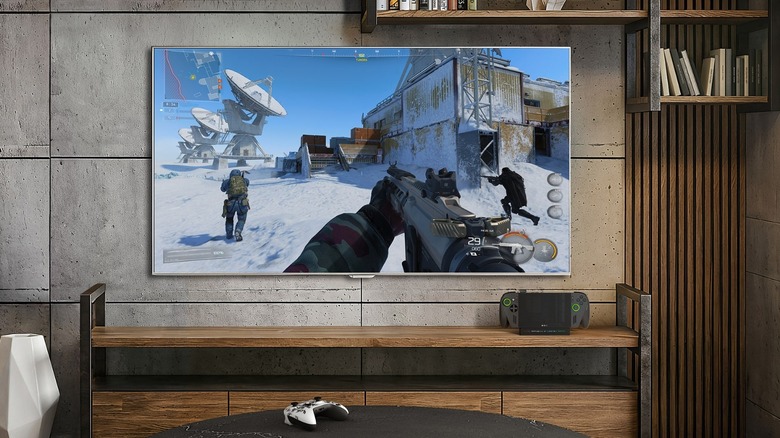 ROG Xbox Ally X docked and displaying via a large screen TV fixed to a concrete wall.