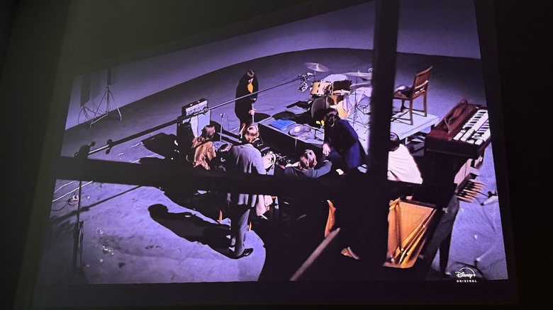 A projection of "The Beatles: Get Back" documentary on a white wall