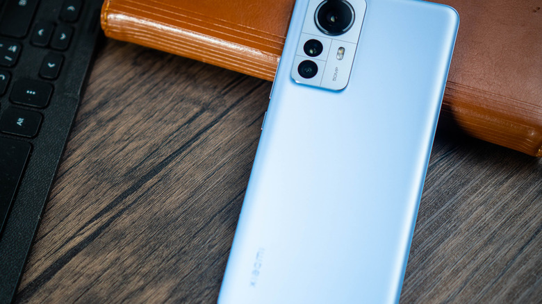 Xiaomi 12 Pro resting atop a desktop journal with keyboard visible.