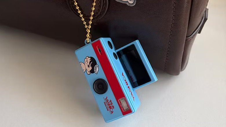 A Yashica Funtastic Keychain Camera attached to a leather bag