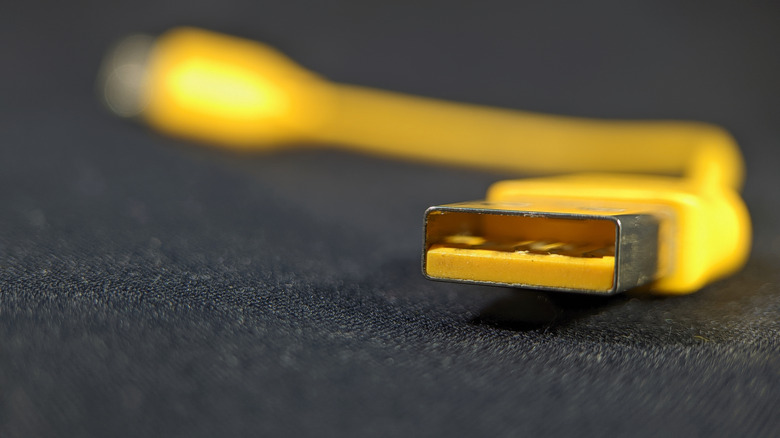 A photograph of a yellow USB connector.
