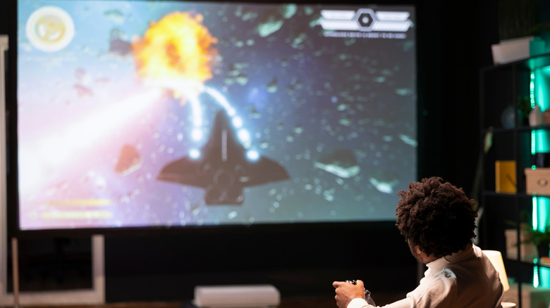 Man playing games on large screen TV.