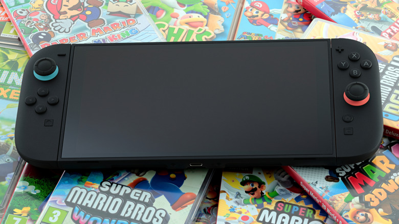 A black Nintendo Switch 2 atop a pile of Switch 2 releases, including several Super Mario games