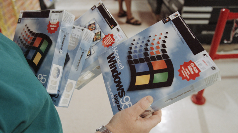 Person holding multiple Windows 95 original retail boxes