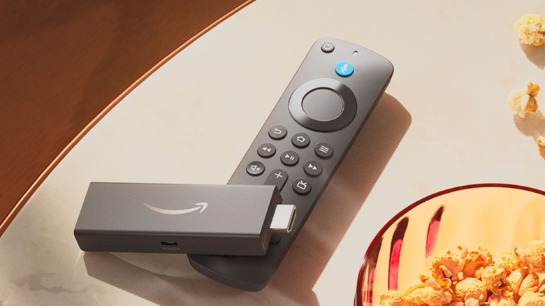 Amazon Fire TV Stick and remote on table next to a bowl of popcorn