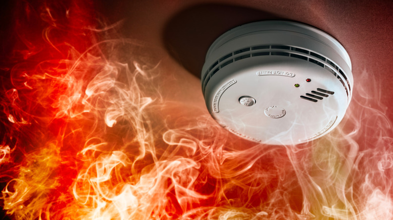 Smoke detector surrounded by flames and smoke