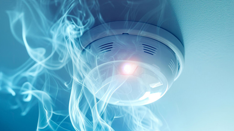Smoke detector with wisps of smoke rising from below