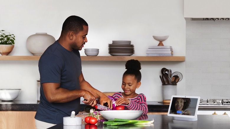 People using the Google Nest Hub Max in the kitchen.