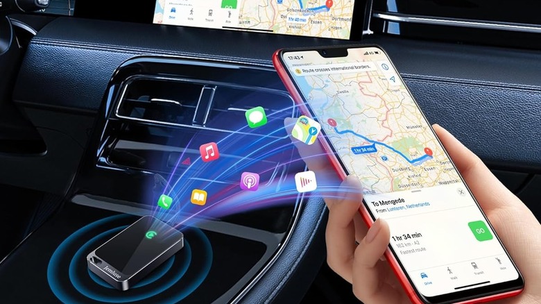 A person connecting their phone to a wireless CarPlay adapter.