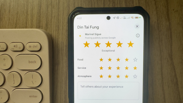 A phone showing a Google Maps rating for a restaurant