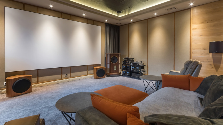 A living room full of AV gear and with a large screen on the wall.