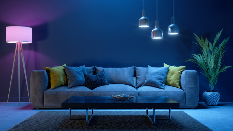 A sofa and coffee table, lit up in blue and purple.