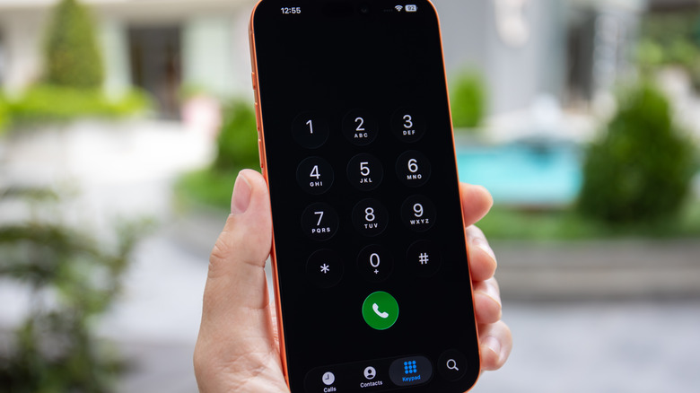 Someone holding up their smartphone with the phone dialer onscreen.
