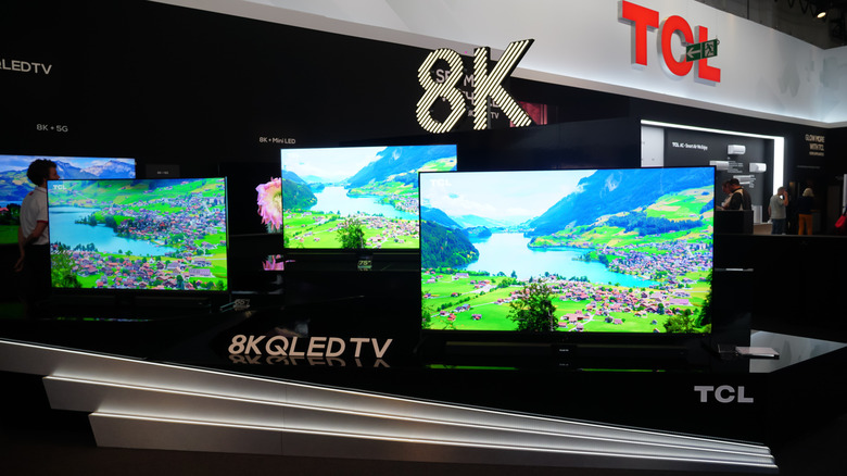 A display stand featuring several 8K TCL TVs
