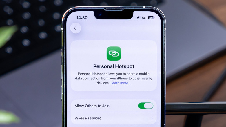 Personal Hotspot settings on an iPhone with a keyboard in the background