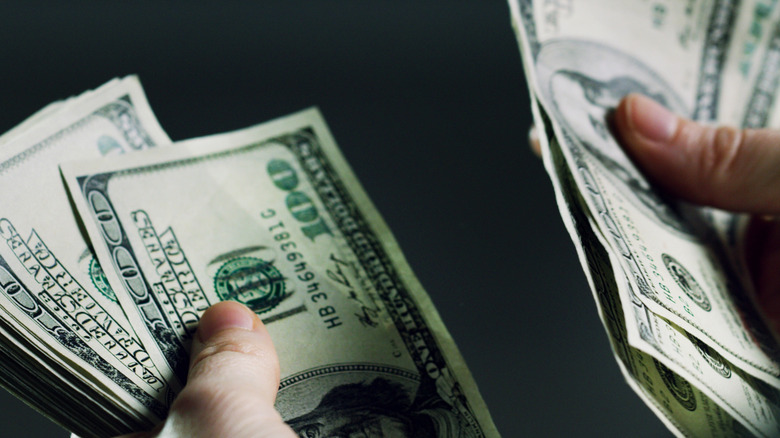 hand holding dollar bills, counting out money
