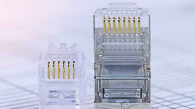 An RJ11 telephone jack plug next to an RJ45 Ethernet plug.