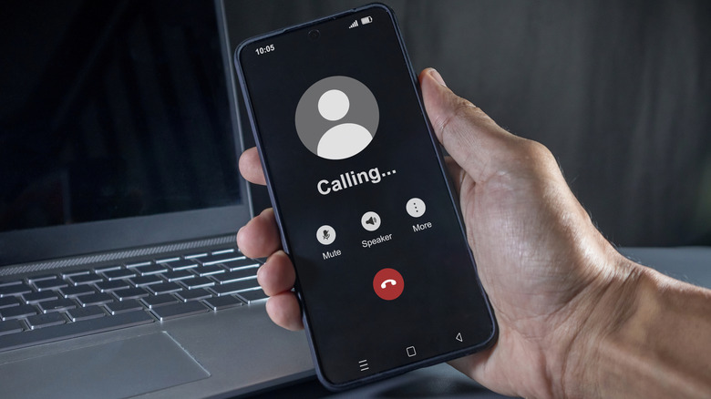 Android phone with outgoing call visible on screen and menu options.