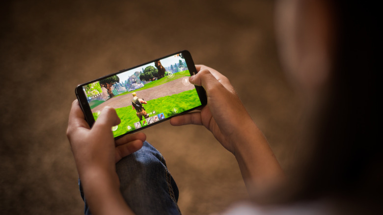 person playing fortnite on a mobile phone