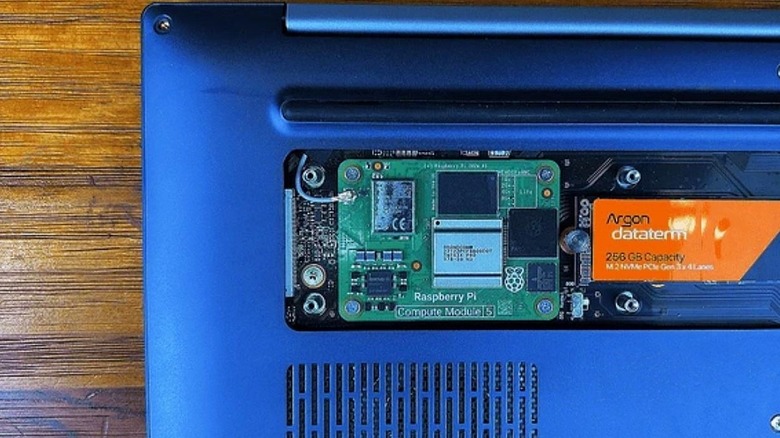 Close up of a Raspberry Pi CM5 and an Argon-branded SSD in an Argon One Up laptop.