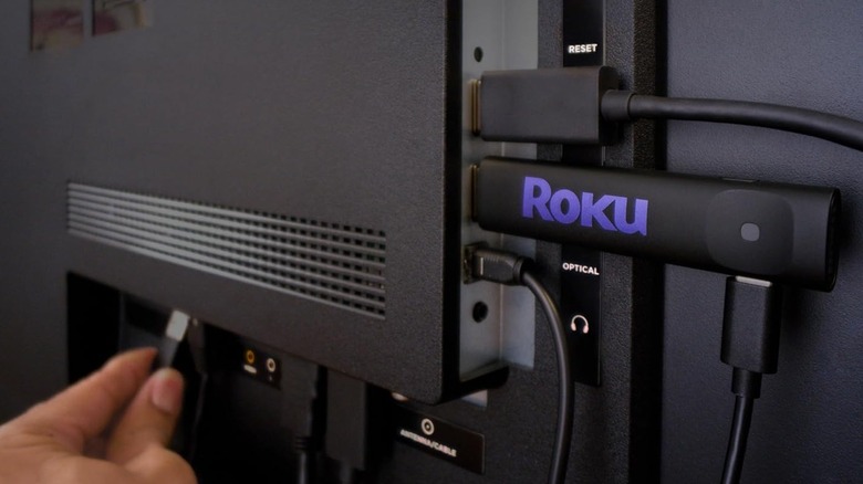 A Roku Streaming Stick connected to the back of a TV.
