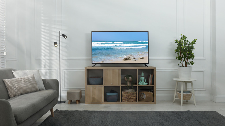 a living room with a TV on a wooden stand.