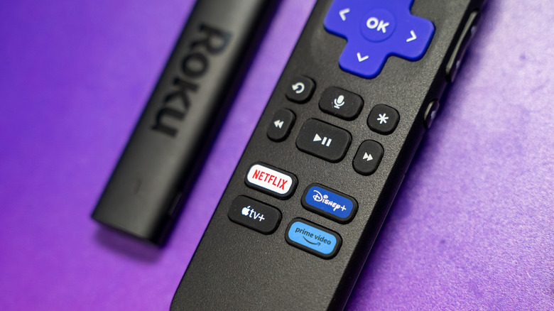 A Roku Streaming Stick next to its remote.