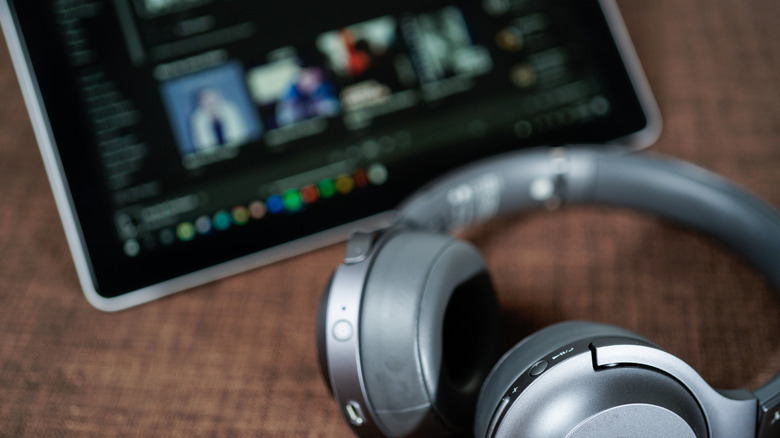 headphones next to tablet PC with Spotify running in the background